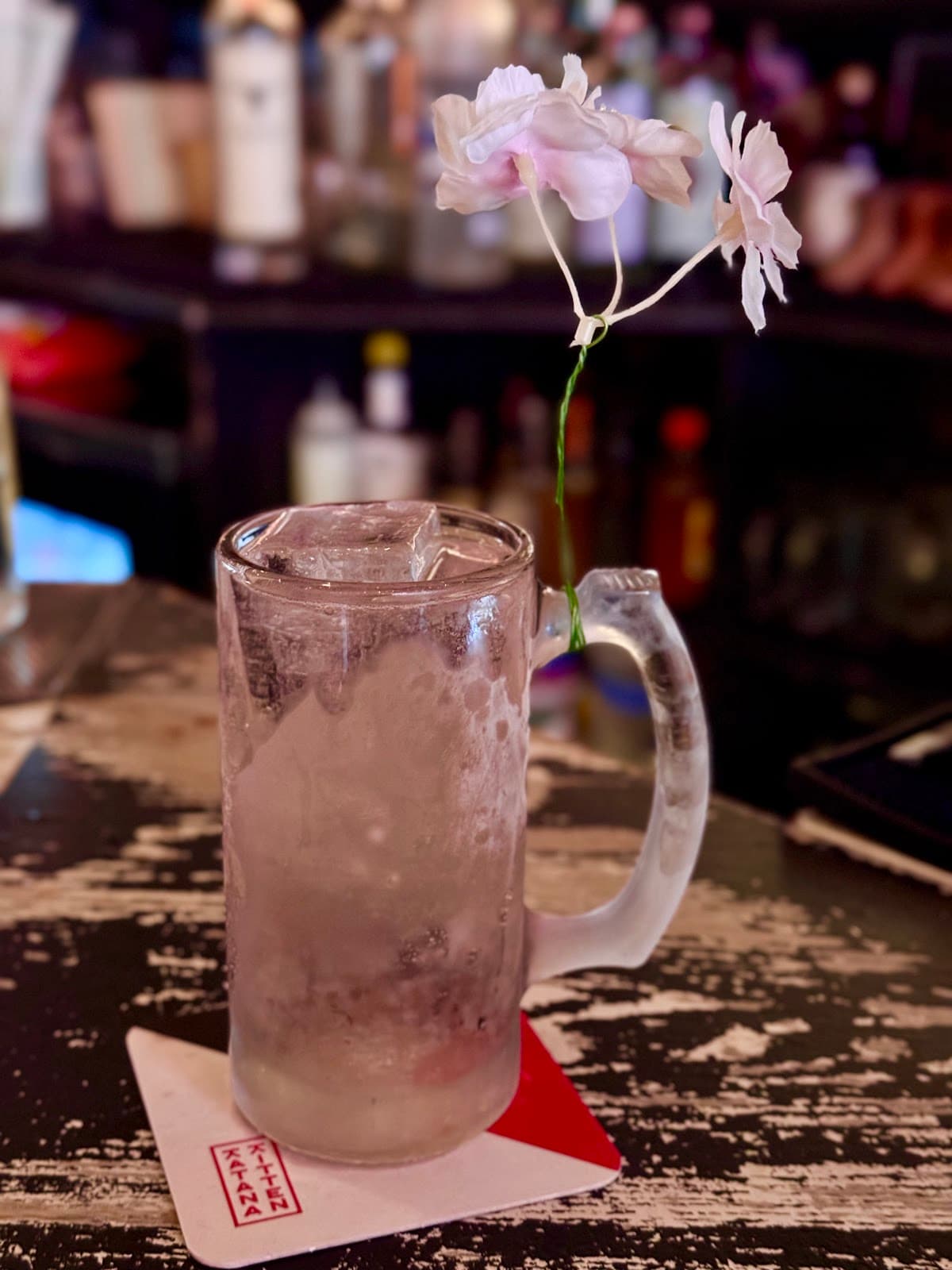 Chilled cocktail glass with ice and a flower garnish on a bar counter in New York