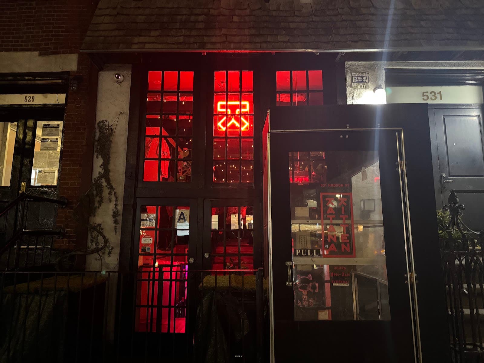 Exterior of a bar with red neon lights at 531 Hudson Street in New York