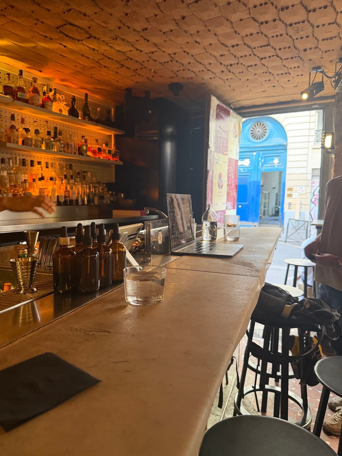 Cozy bar counter with bottles and warm lighting in Paris