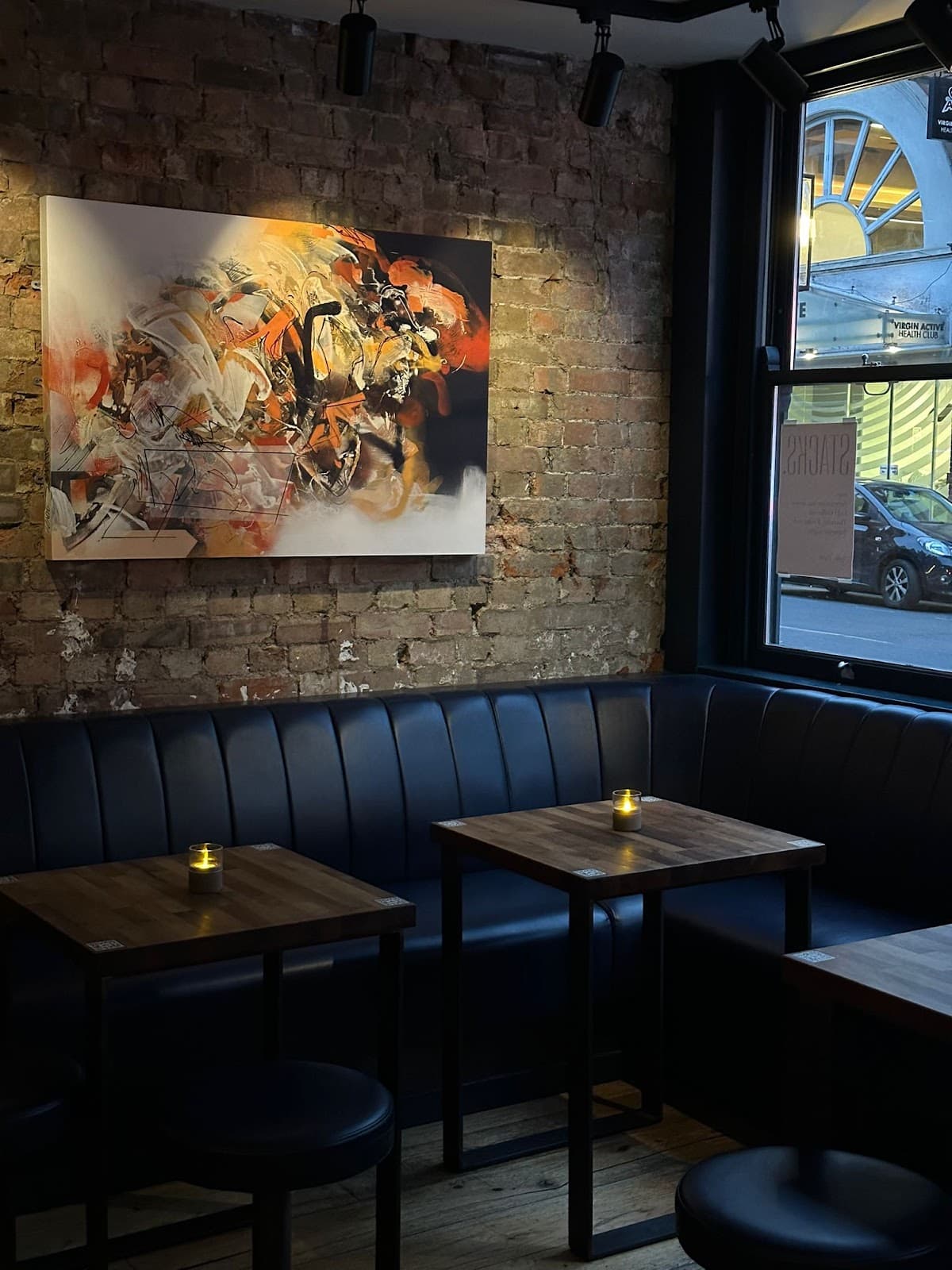 Interior of a bar with leather seating and candlelit tables in London