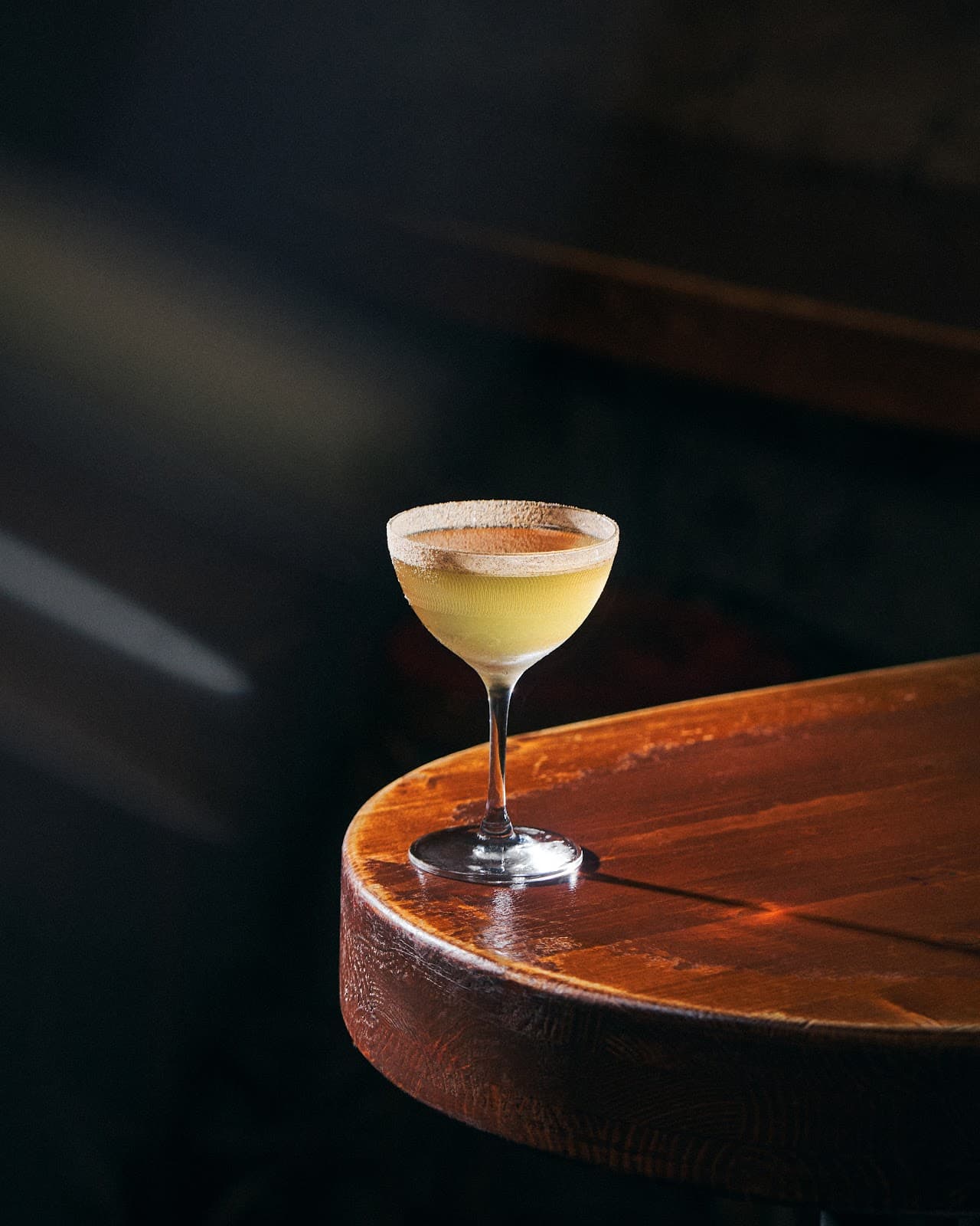 Elegant cocktail in a coupe glass on a wooden table in Paris