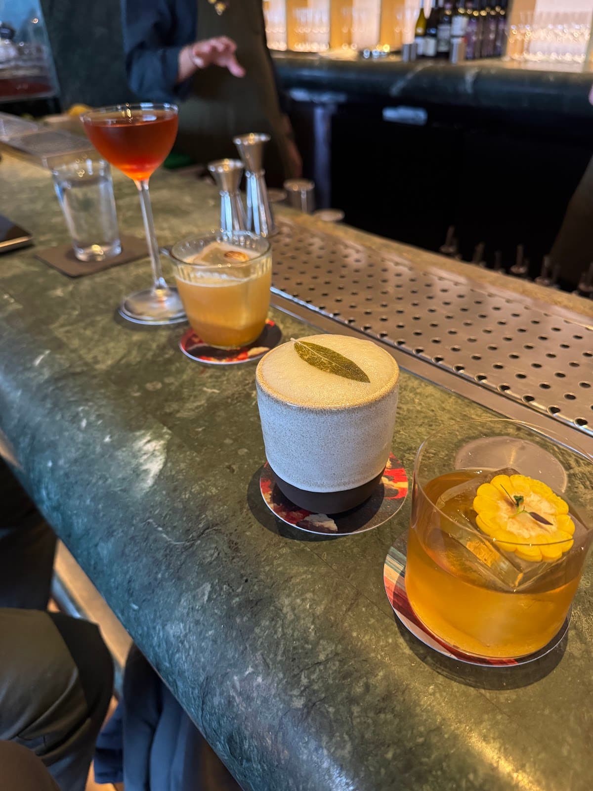 Close-up of a marble bar with a variety of cocktails and bar tools in London