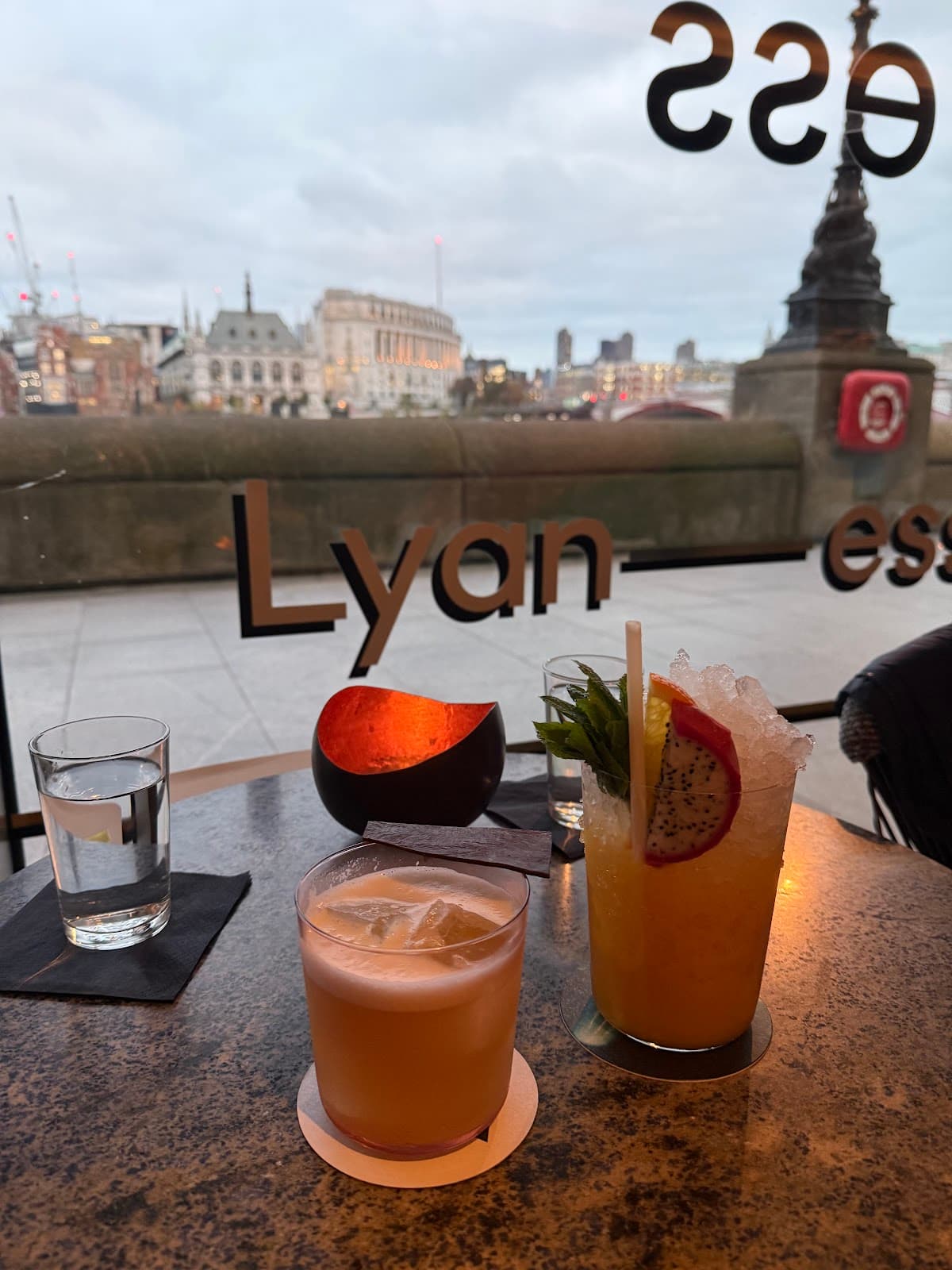 Two cocktails on a table with cityscape view at Lyaness in London