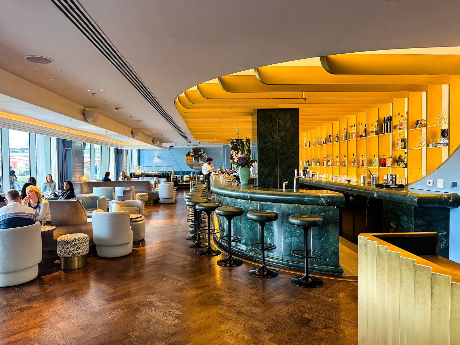 Elegant bar interior with green marble counter and gold accents in London