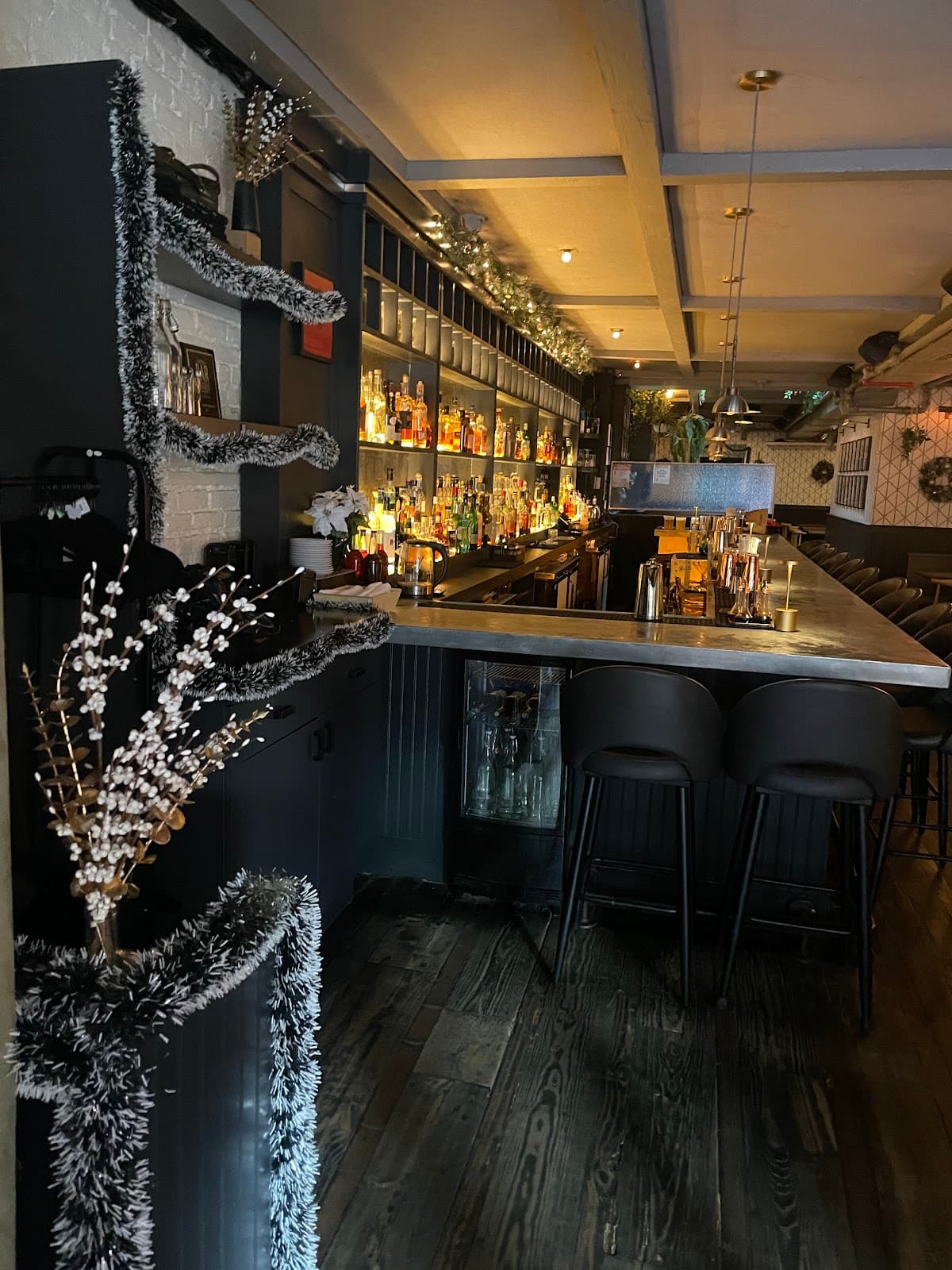 Stylish bar interior with illuminated bottles and dark wood accents in New York