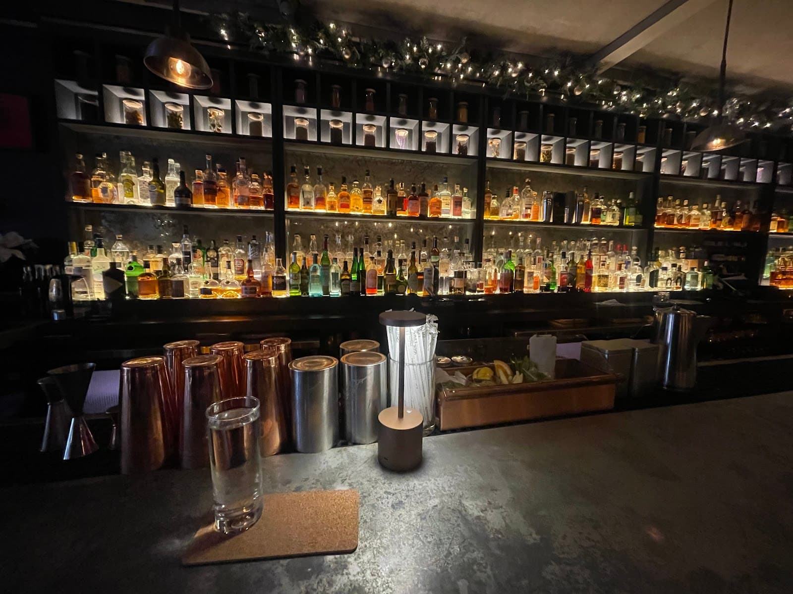 Premium bar with backlit shelves displaying various spirits and decor lighting in New York