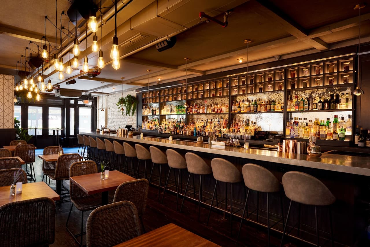 Stylish bar interior with hanging lights and stocked shelves