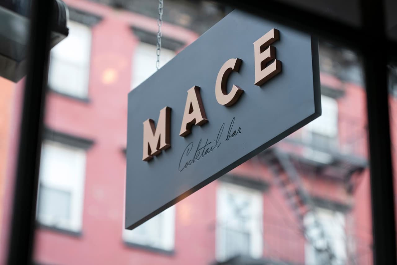 Sign reading MACE Cocktail Bar hanging outside building in New York