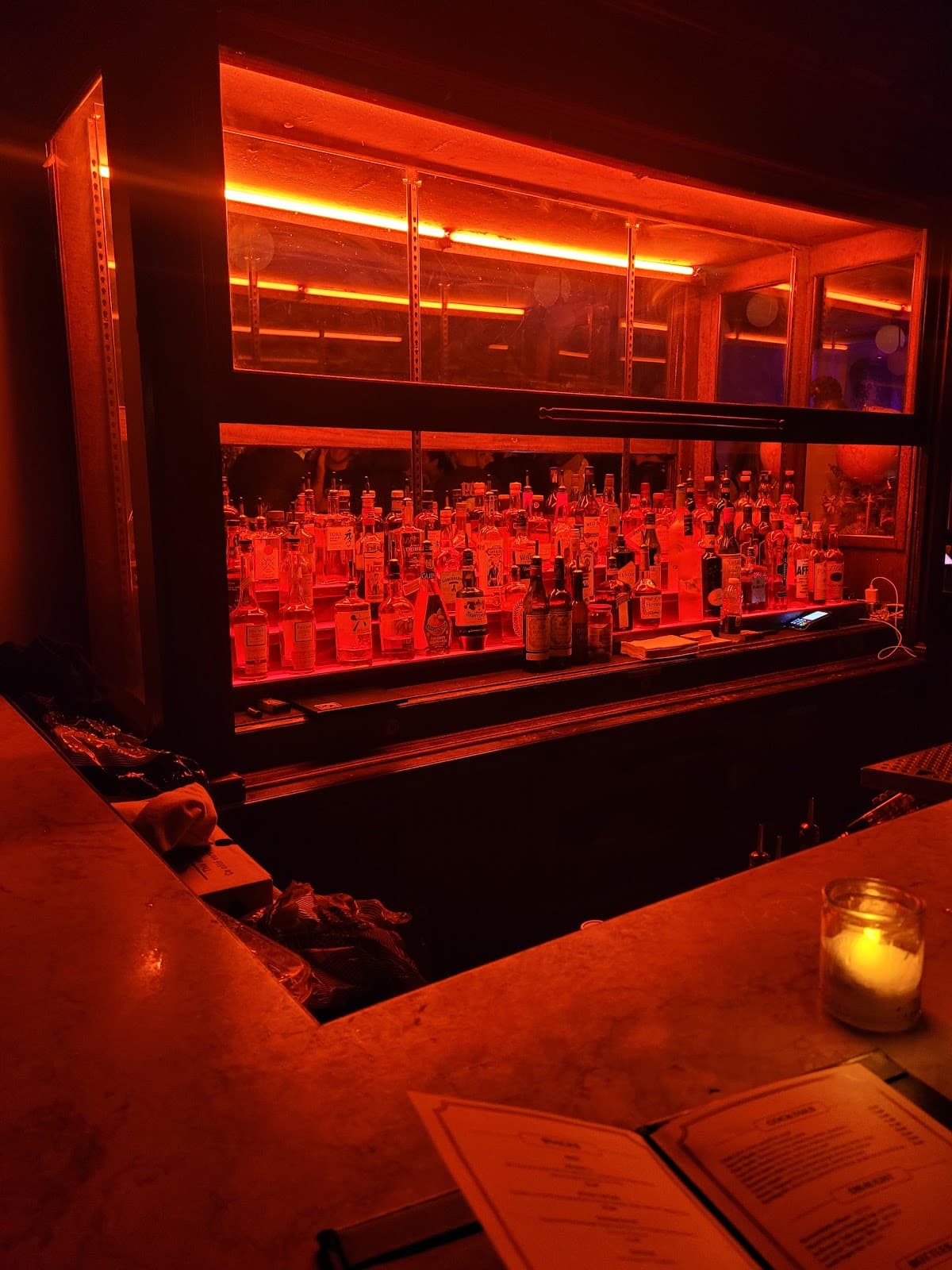 Bar counter with backlit bottles and warm lighting in Toronto