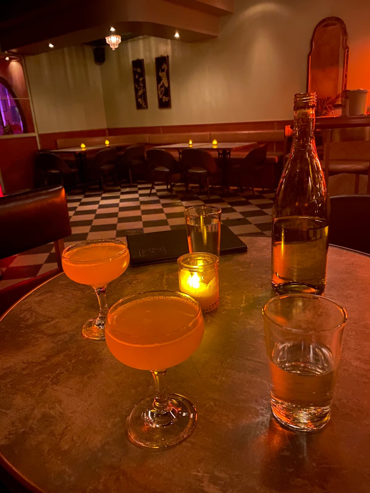 Cocktail glasses on a dimly lit table with a cozy bar background in Toronto