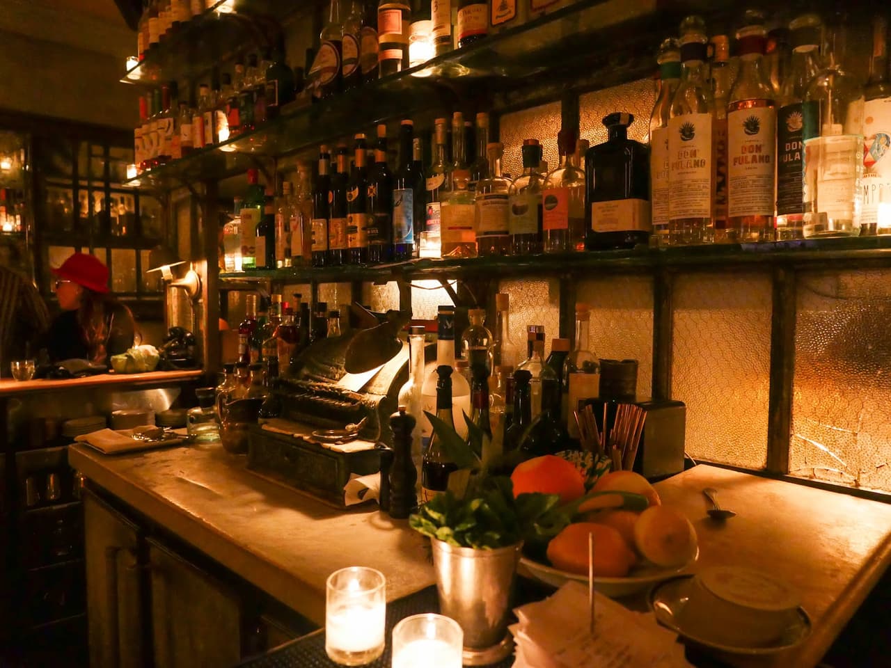 Cozy bar with dim lighting and bottles on shelves in New York