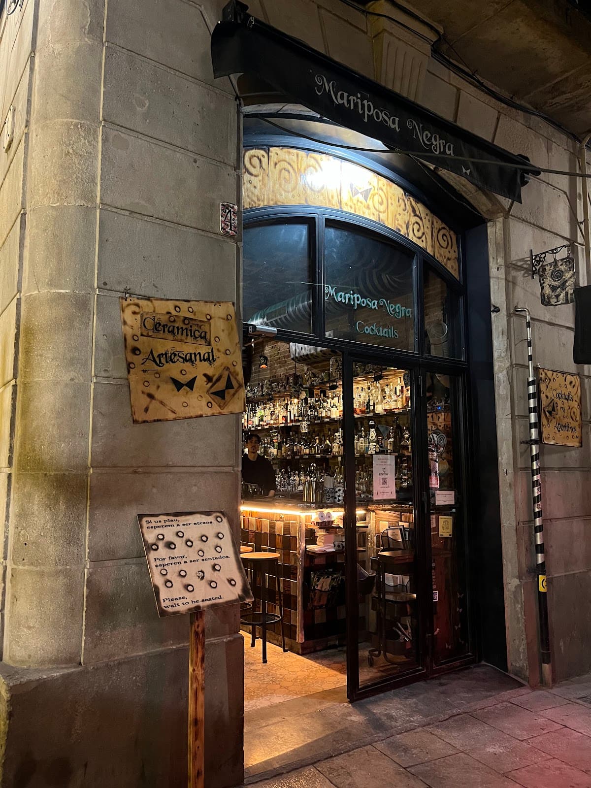Exterior of Mariposa Negra cocktail bar with entrance and signage in Barcelona
