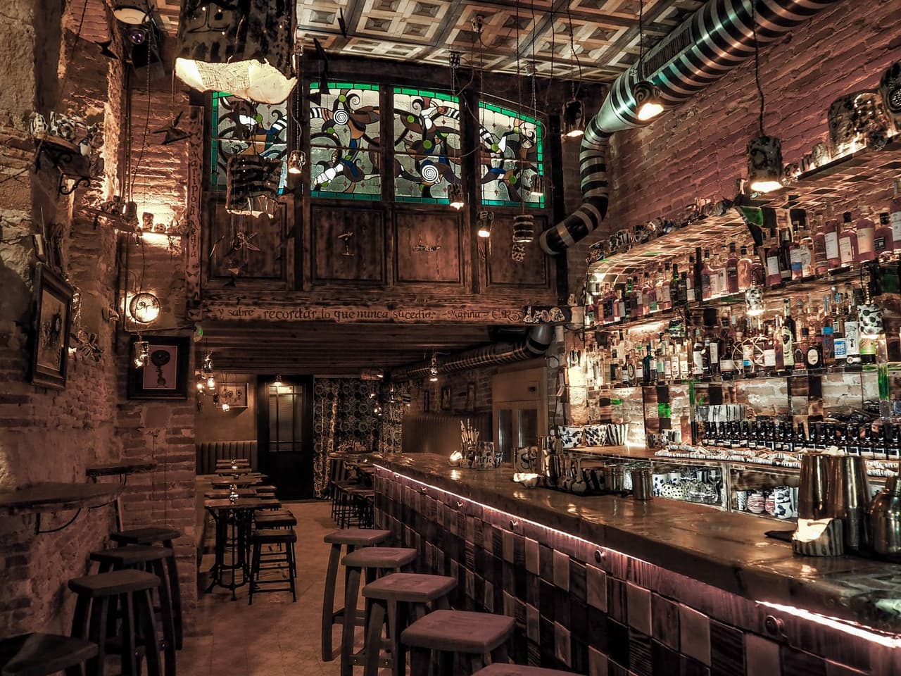 Rustic cocktail bar with exposed brick and stained glass windows