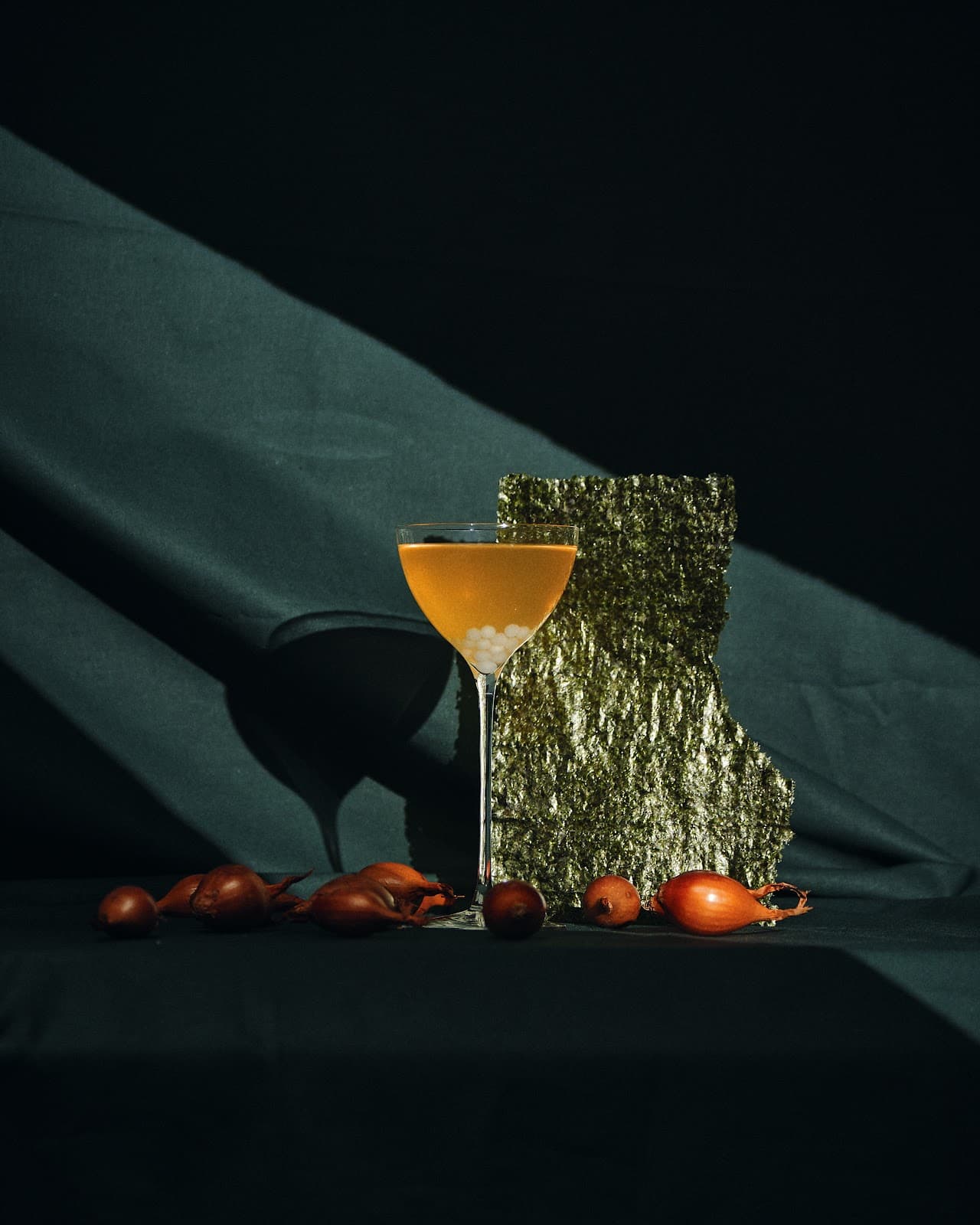 Elegant cocktail in a glass with onions and textured backdrop in Paris