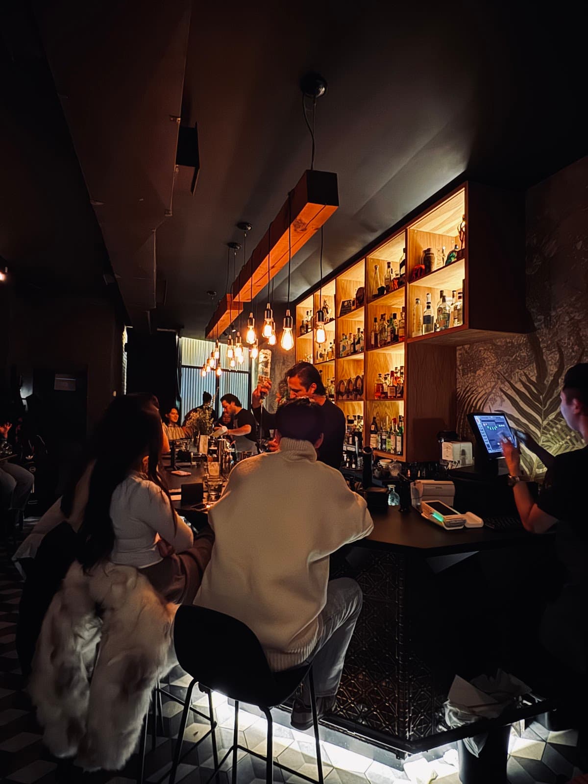 Stylish bar interior with patrons seated and warm lighting in Toronto
