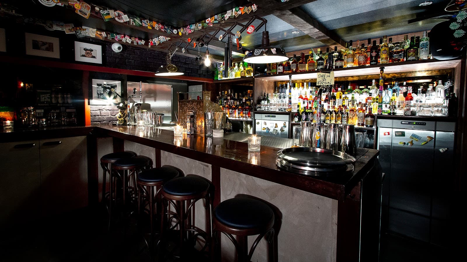 Well-stocked bar counter with stools and ambient lighting
