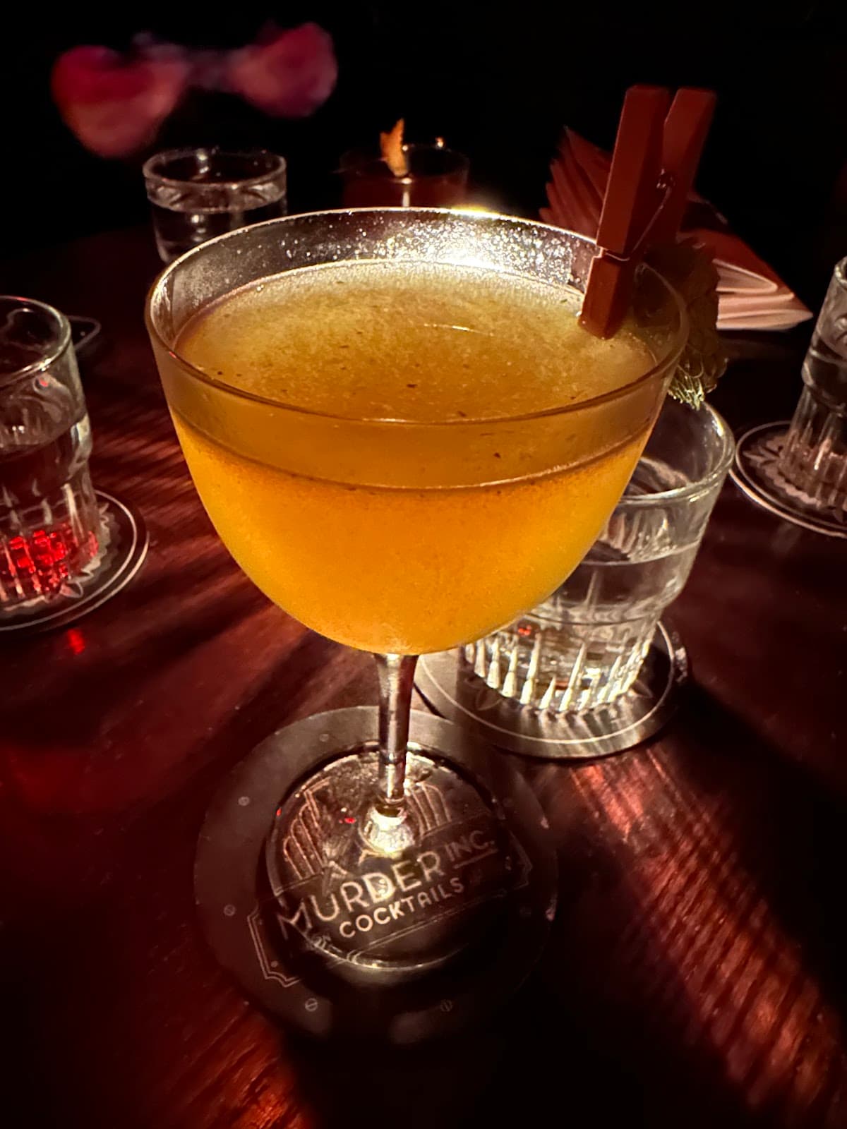 Close-up of a cocktail on a wooden table at Murder Inc in London