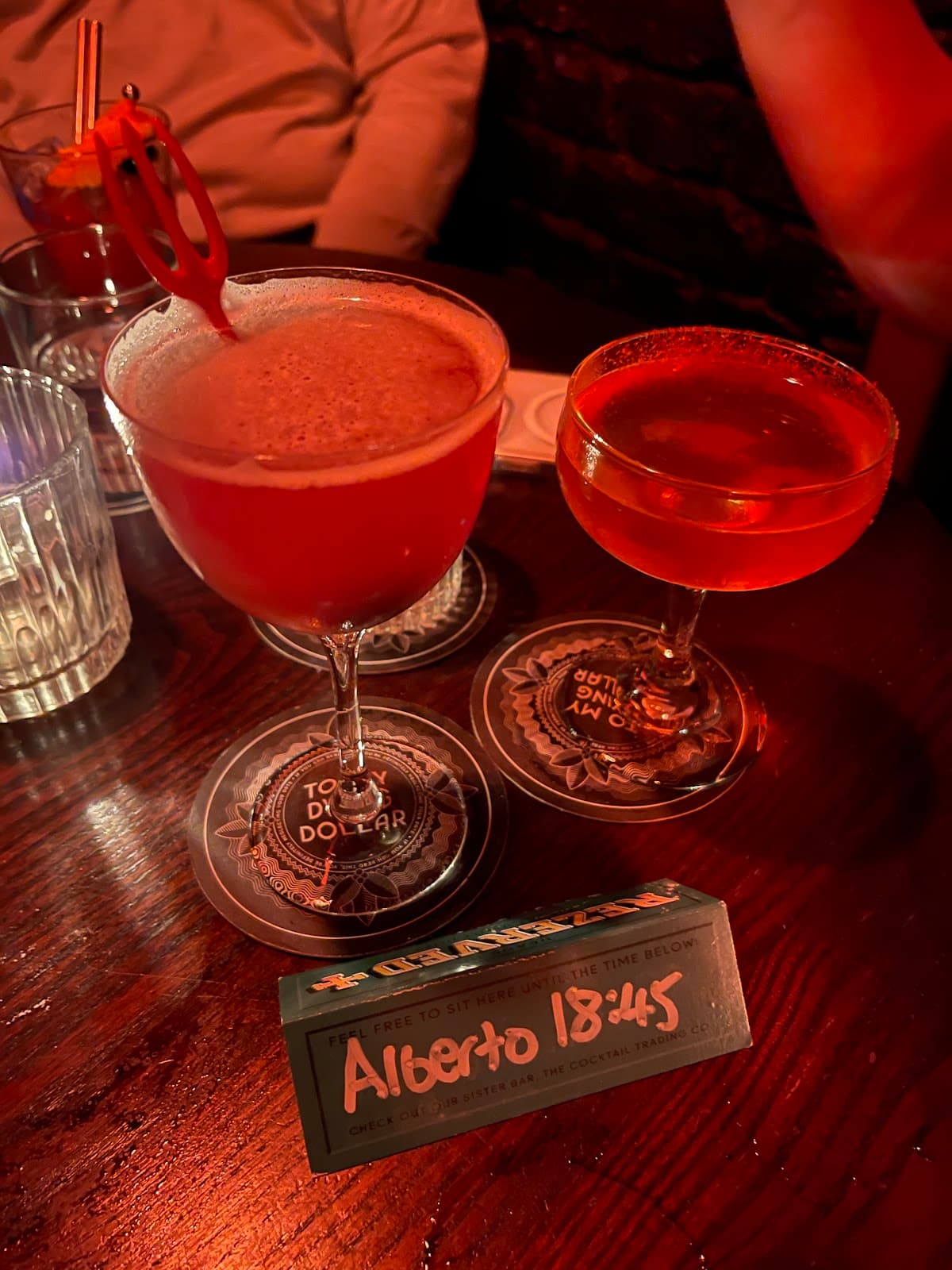 Two cocktails on a table with a reserved sign for Alberto in London