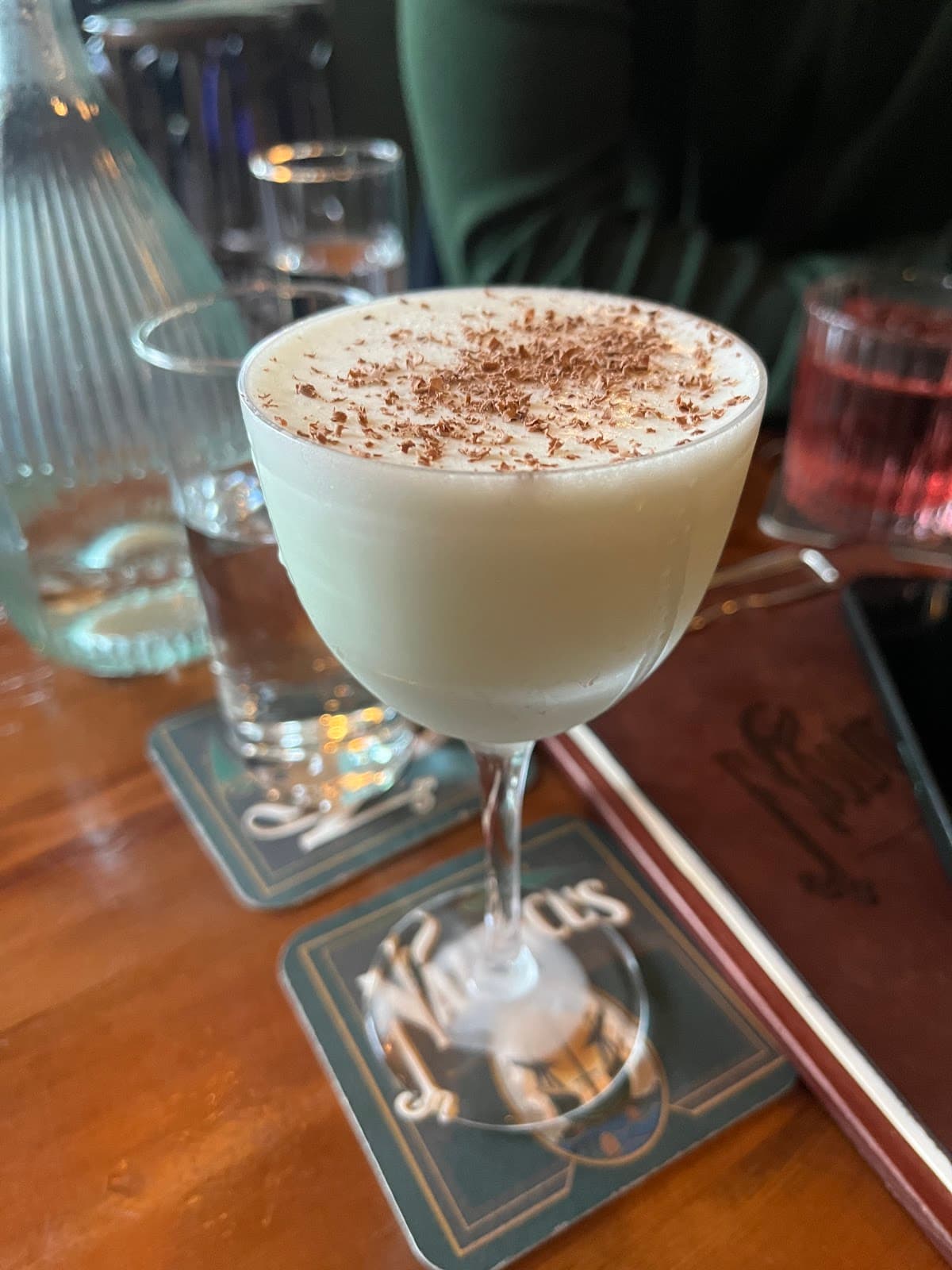 Close-up of a creamy cocktail with chocolate shavings on a wooden bar in Edinburgh