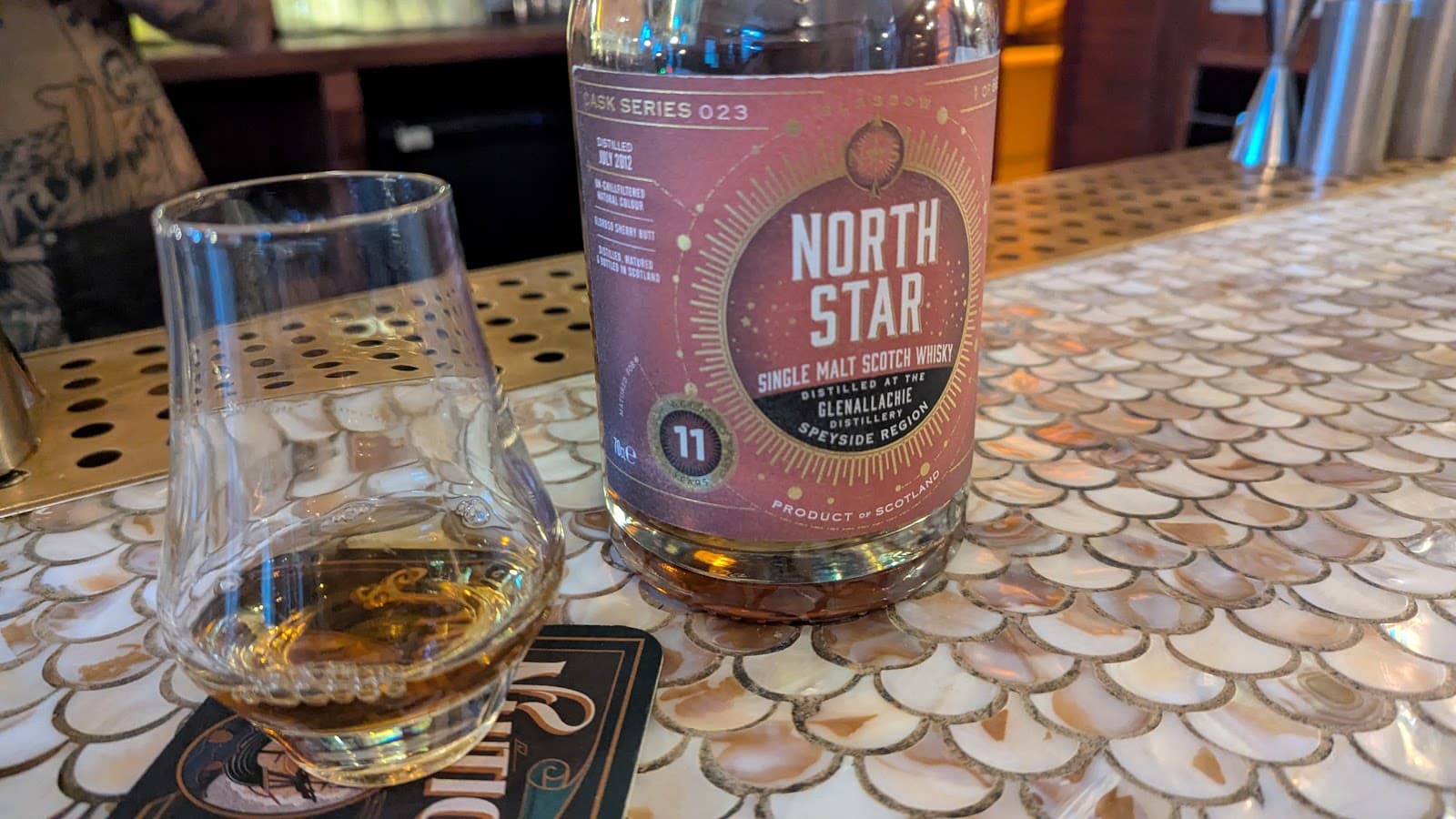 Close-up of North Star whisky bottle and glass on decorative bar counter in Edinburgh