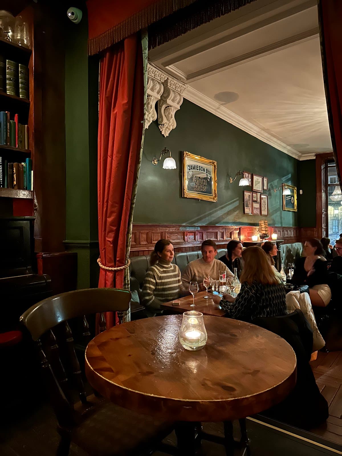 Cozy bar interior with wooden tables and people dining