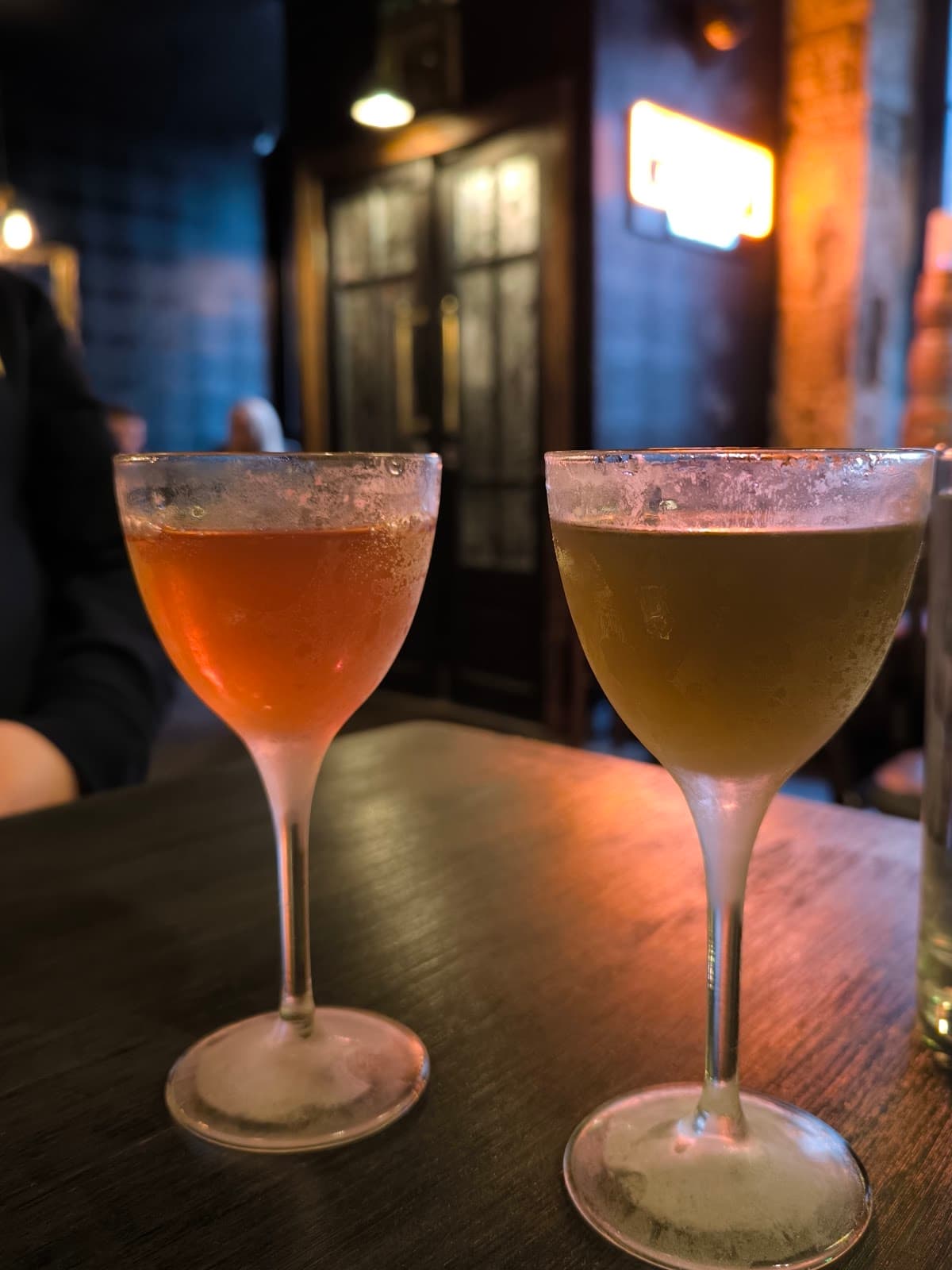 Two cocktails on a table in a dimly lit bar setting in Edinburgh