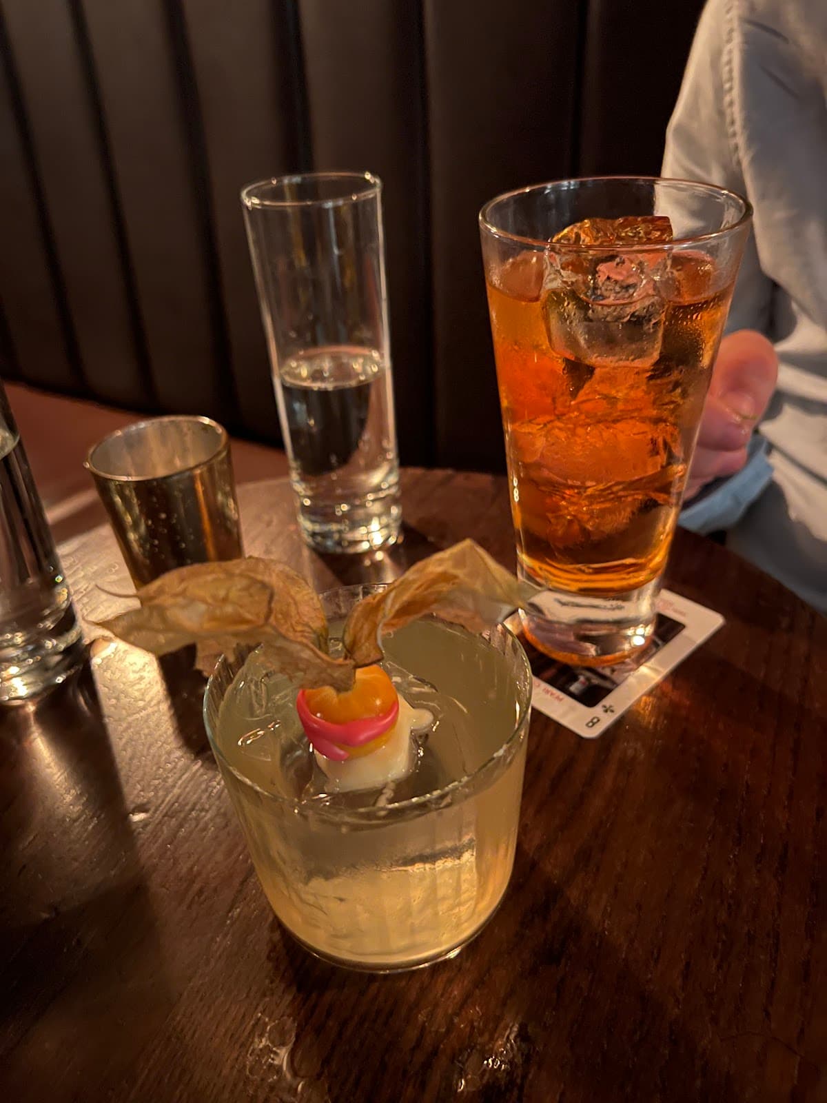 Close-up of cocktails on a dimly lit wooden table in London