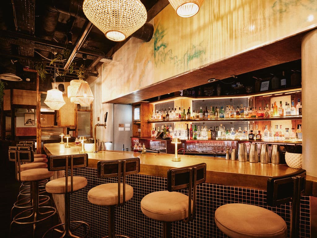 Chic bar interior with stylish lighting and stocked bar shelves in London