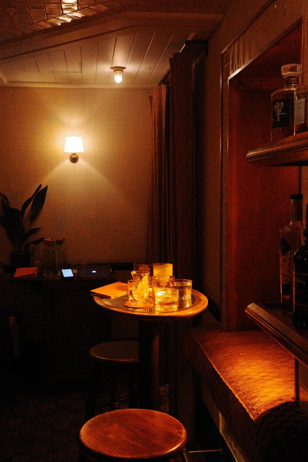 Cozy interior with a small round table and bottles, dimly lit atmosphere in London