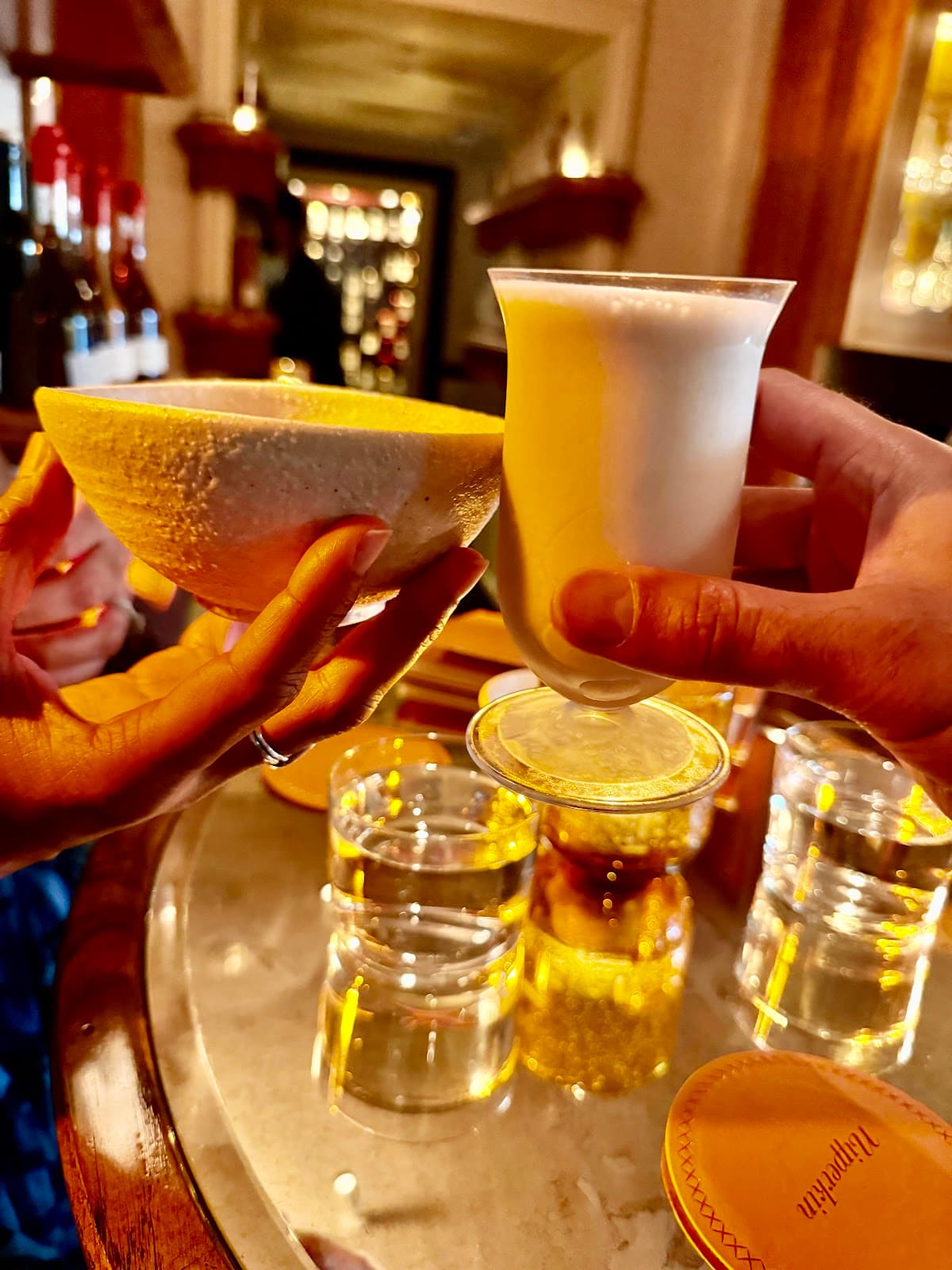 Close-up of unique cocktails held above a reflective table in London