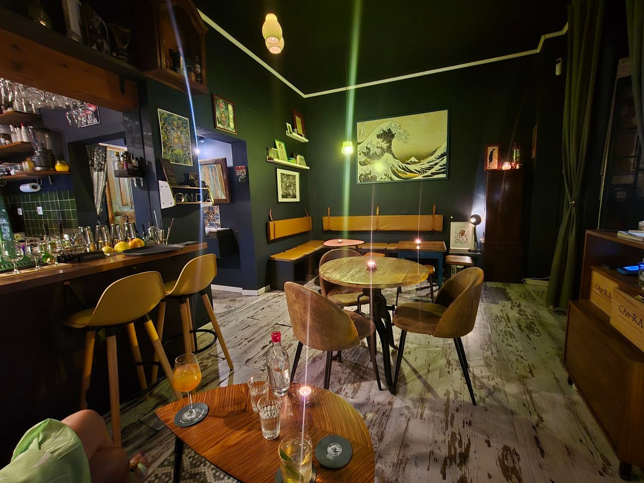 Stylish bar interior with wooden furniture and artwork on dark walls