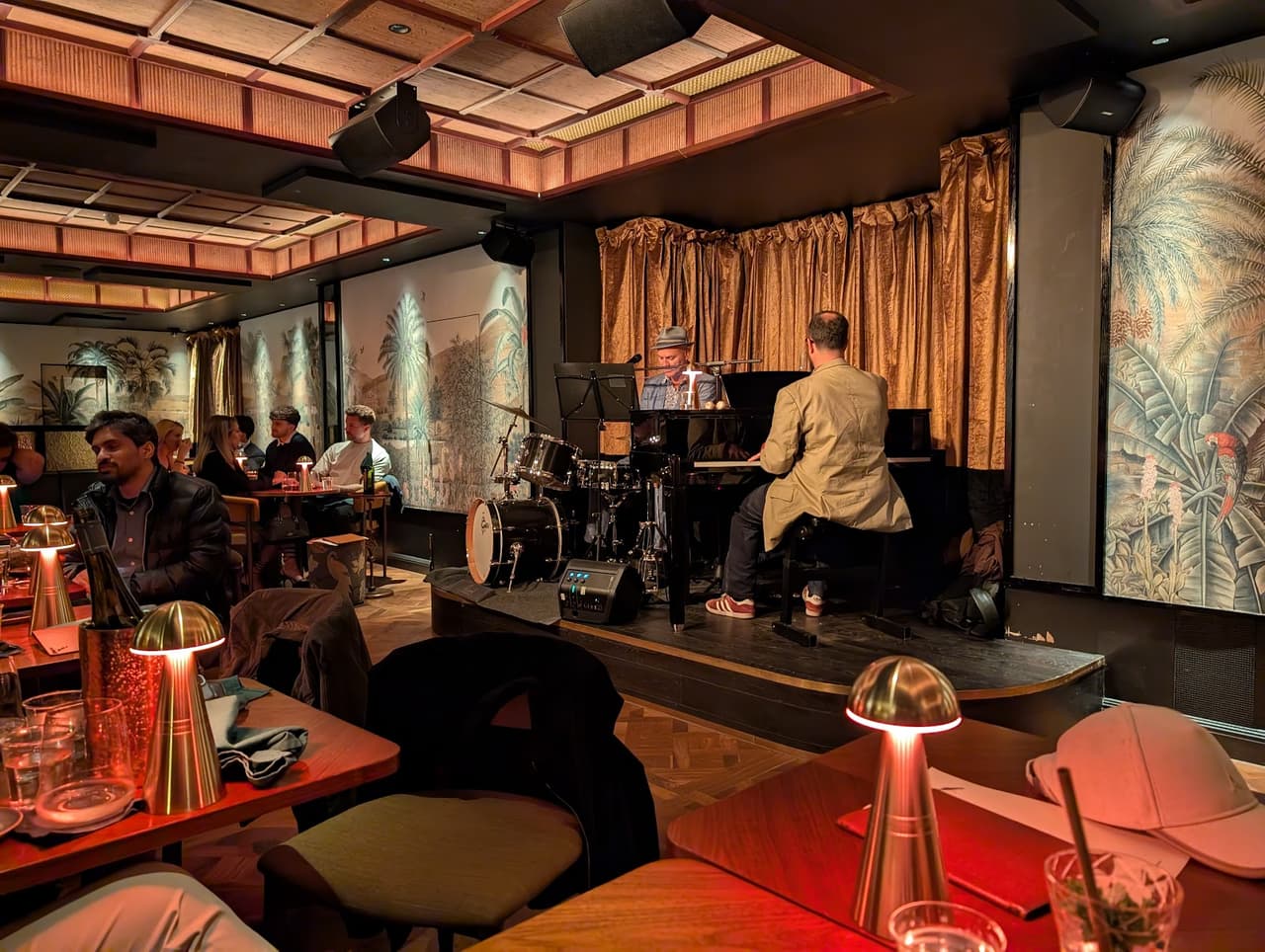 Live music setup in a warmly lit cocktail bar with decorative wall art in London