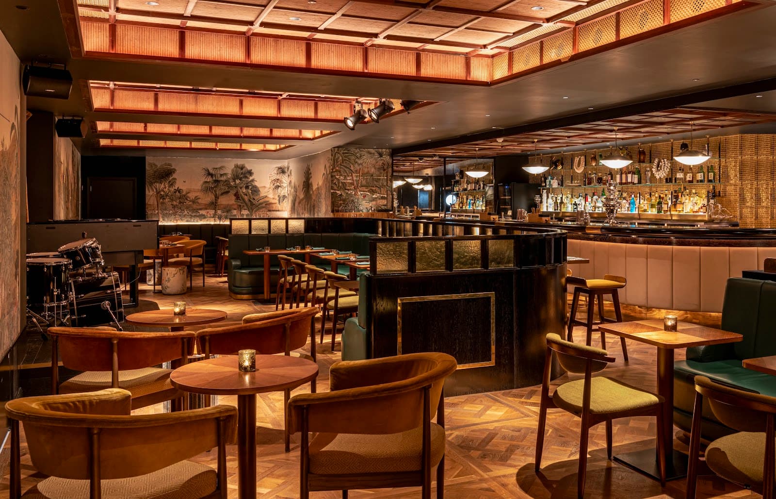 Warmly lit interior of a cocktail bar with elegant seating and bar counter