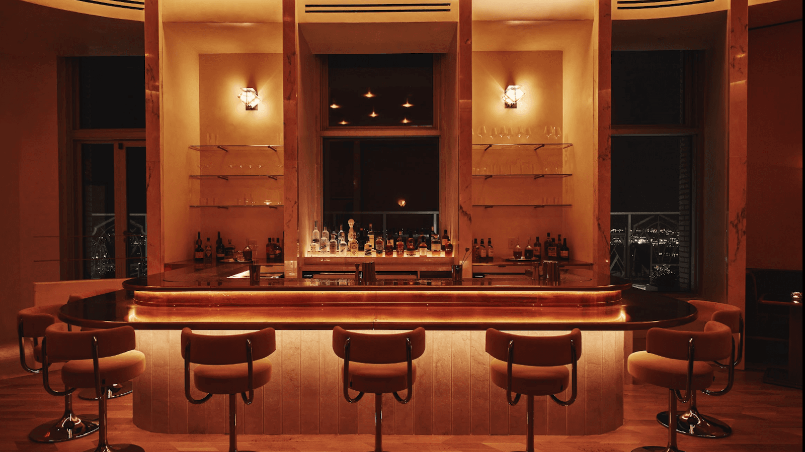 Elegant bar counter with warm lighting and stocked shelves at night in New York
