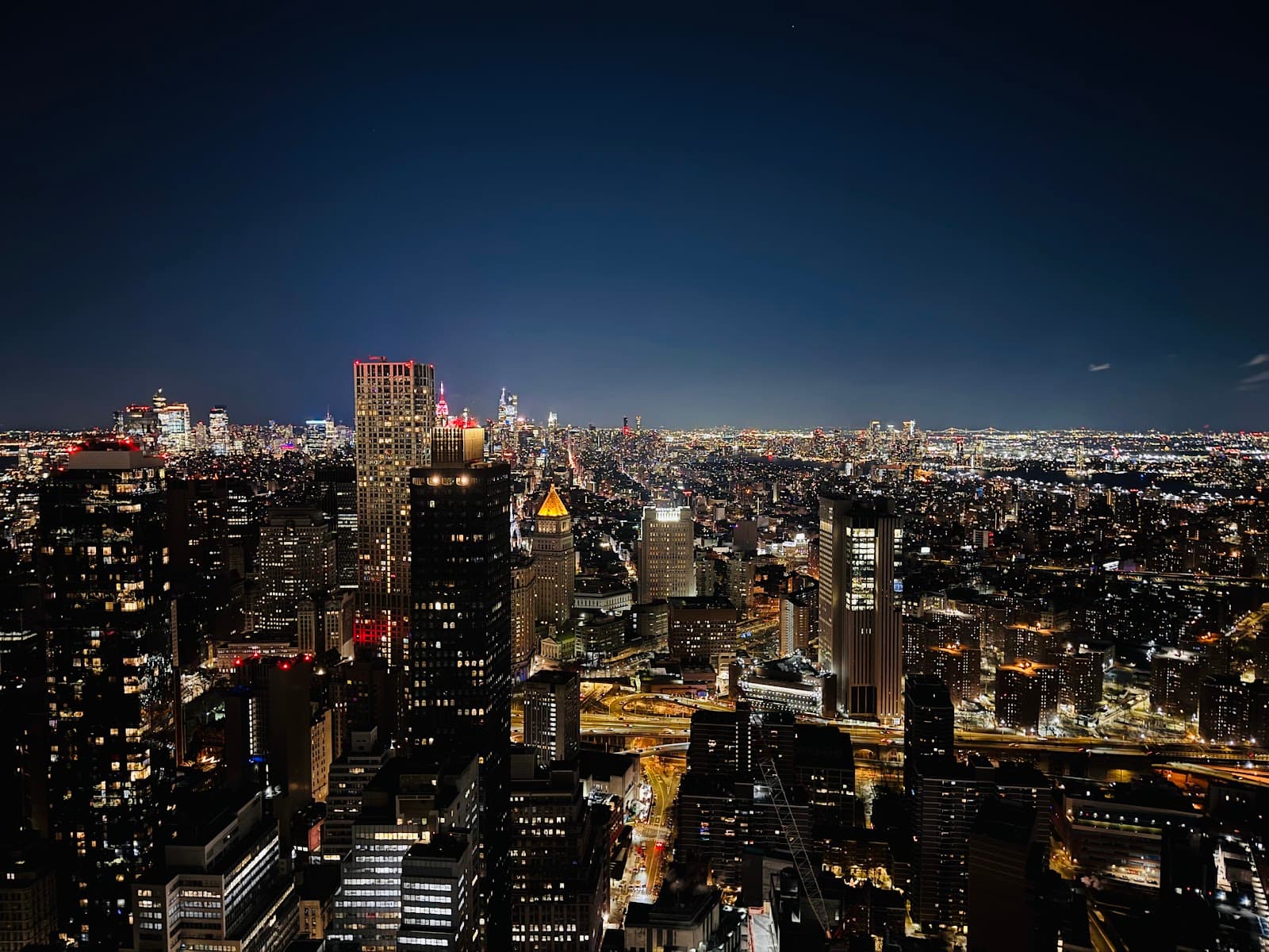 Aerial night view of a city skyline with illuminated buildings in New York