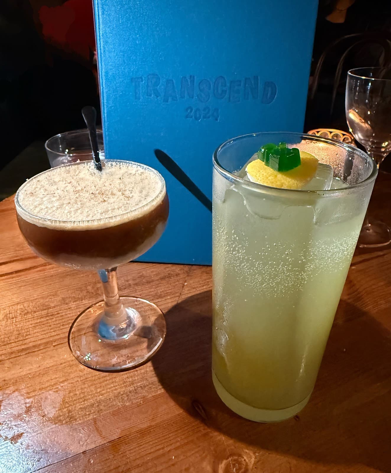 Pair of cocktails with a blue 'TRANSCEND 2024' menu in the background in Edinburgh