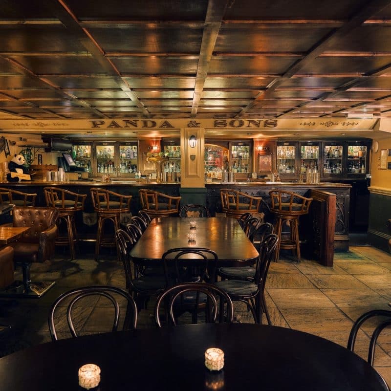 Warm interior of Panda & Sons bar with wooden flooring and bar stools