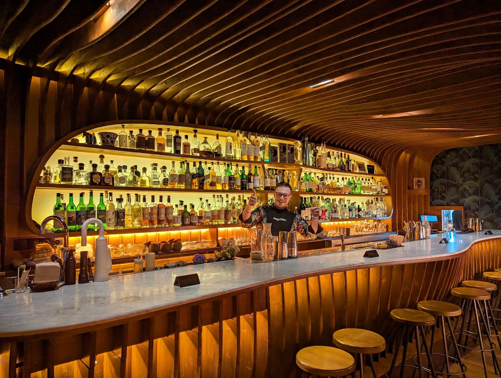 Stylish bar interior with a bartender and curved wooden design