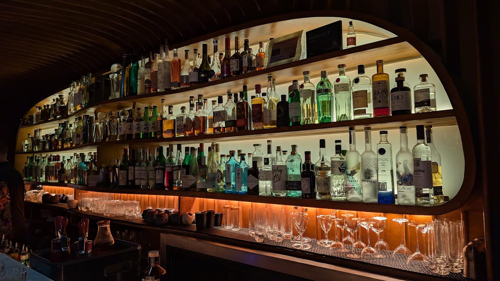 Backlit bar shelves with assorted liquor bottles displayed in Barcelona