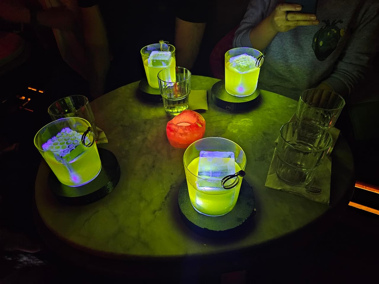 Table with uniquely lit cocktails in a dimly lit bar setting in Barcelona