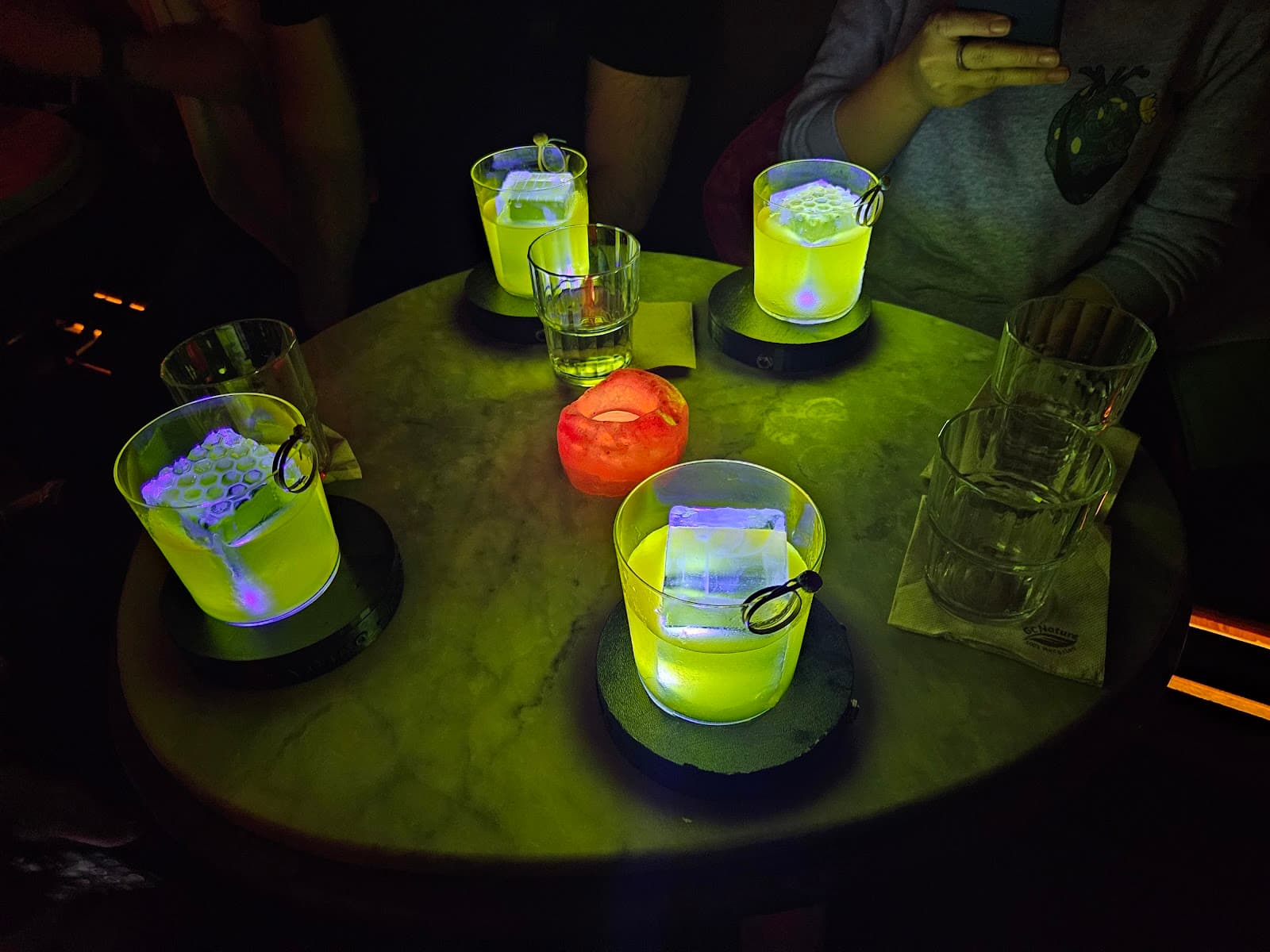 Table with uniquely lit cocktails in a dimly lit bar setting in Barcelona