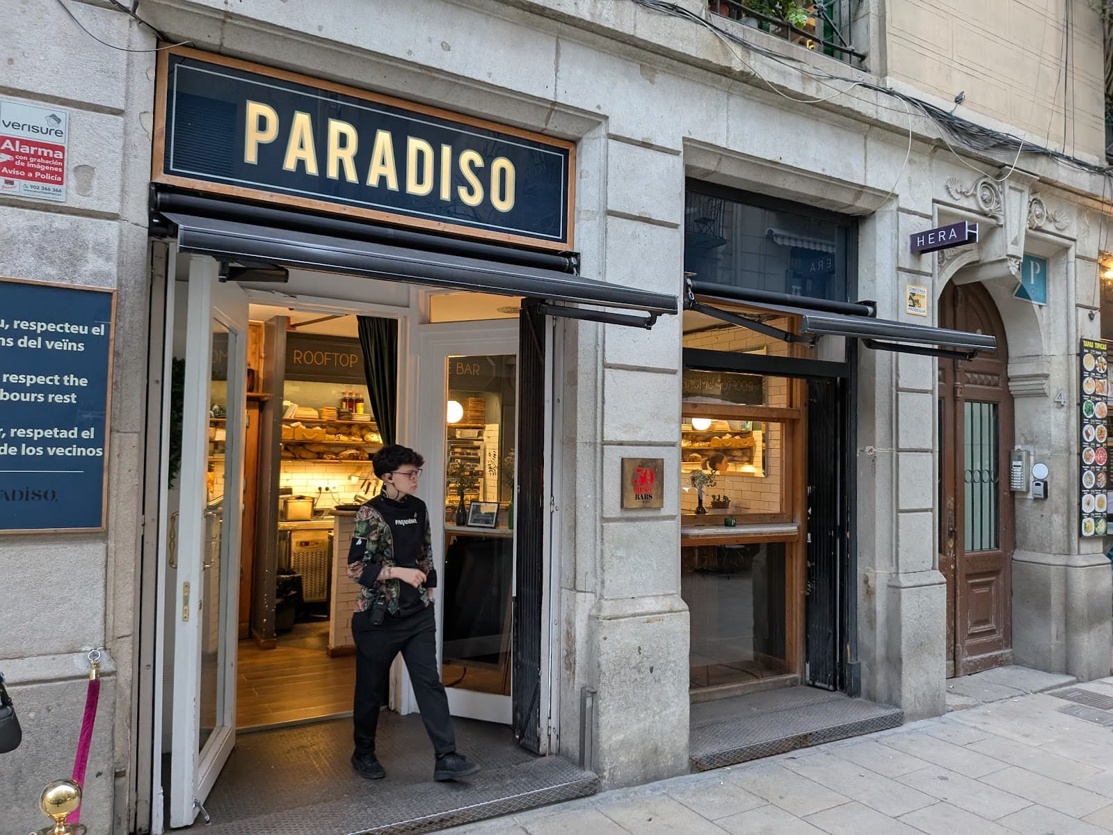 Exterior view of Paradiso with open doors and a person walking out in Barcelona