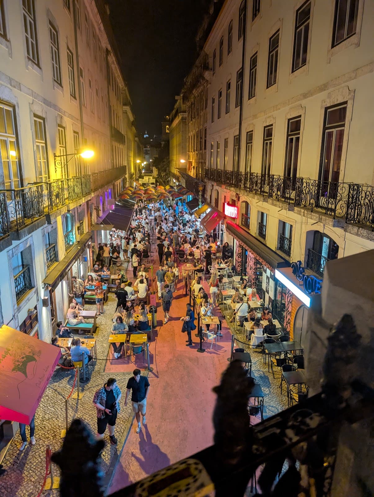 Vibrant night street scene with outdoor dining and illuminated buildings in Lisboa