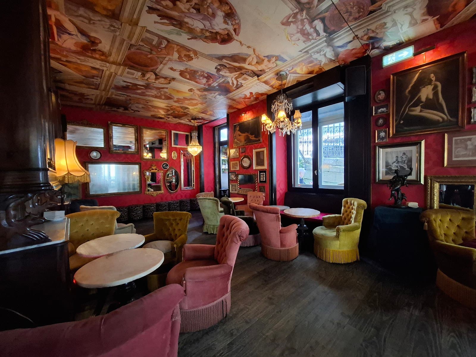 Opulent cocktail bar interior with ornate ceiling and plush seating