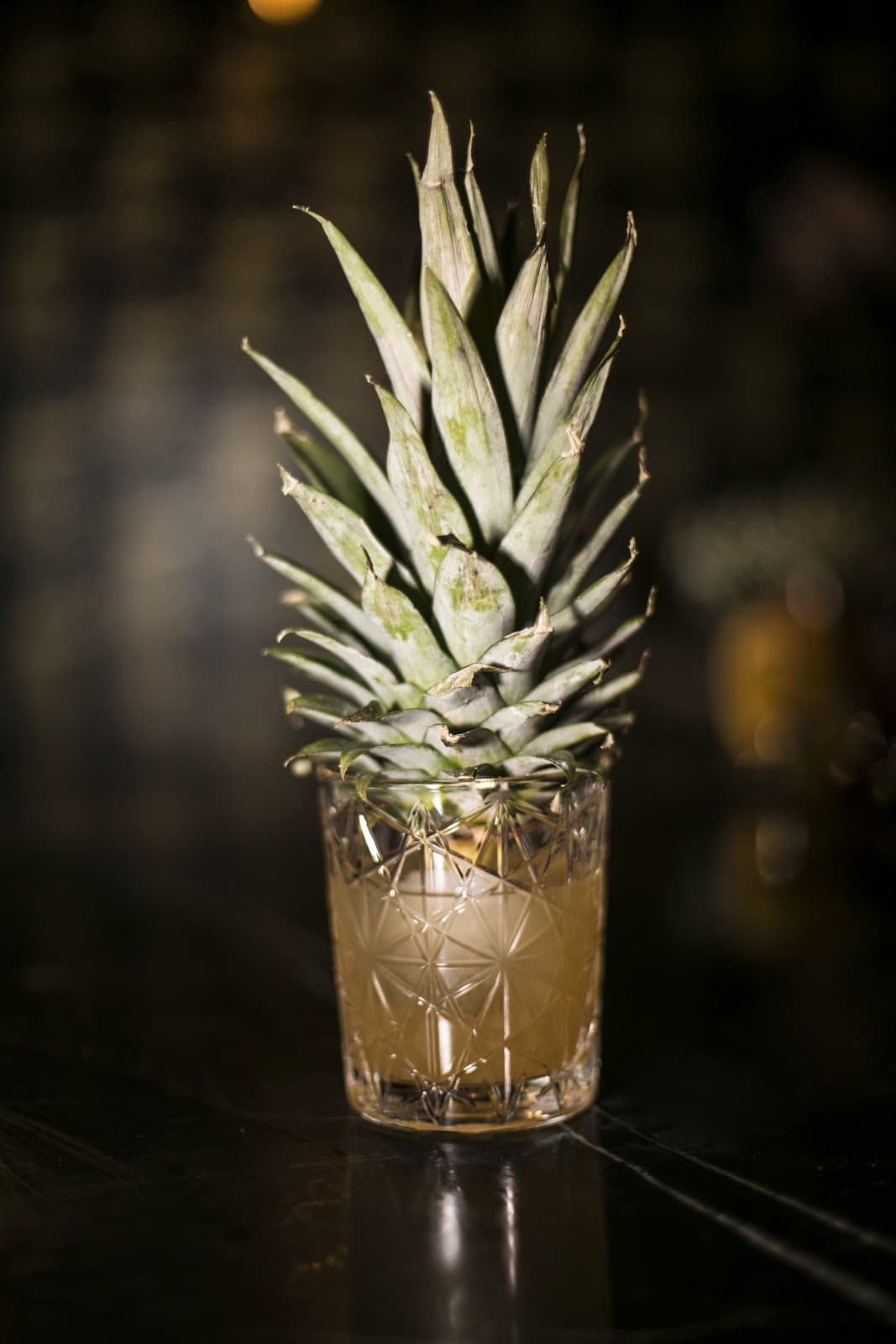 Creative cocktail with pineapple garnish in a patterned glass in New York