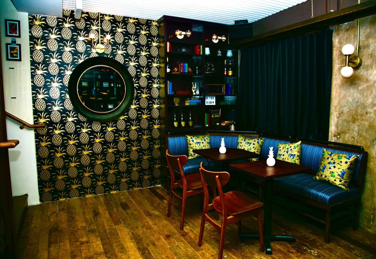 Stylish interior with patterned walls and dark blue seating in a cocktail bar in New York