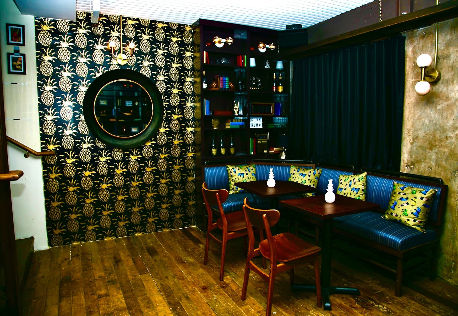 Stylish interior with patterned walls and dark blue seating in a cocktail bar in New York