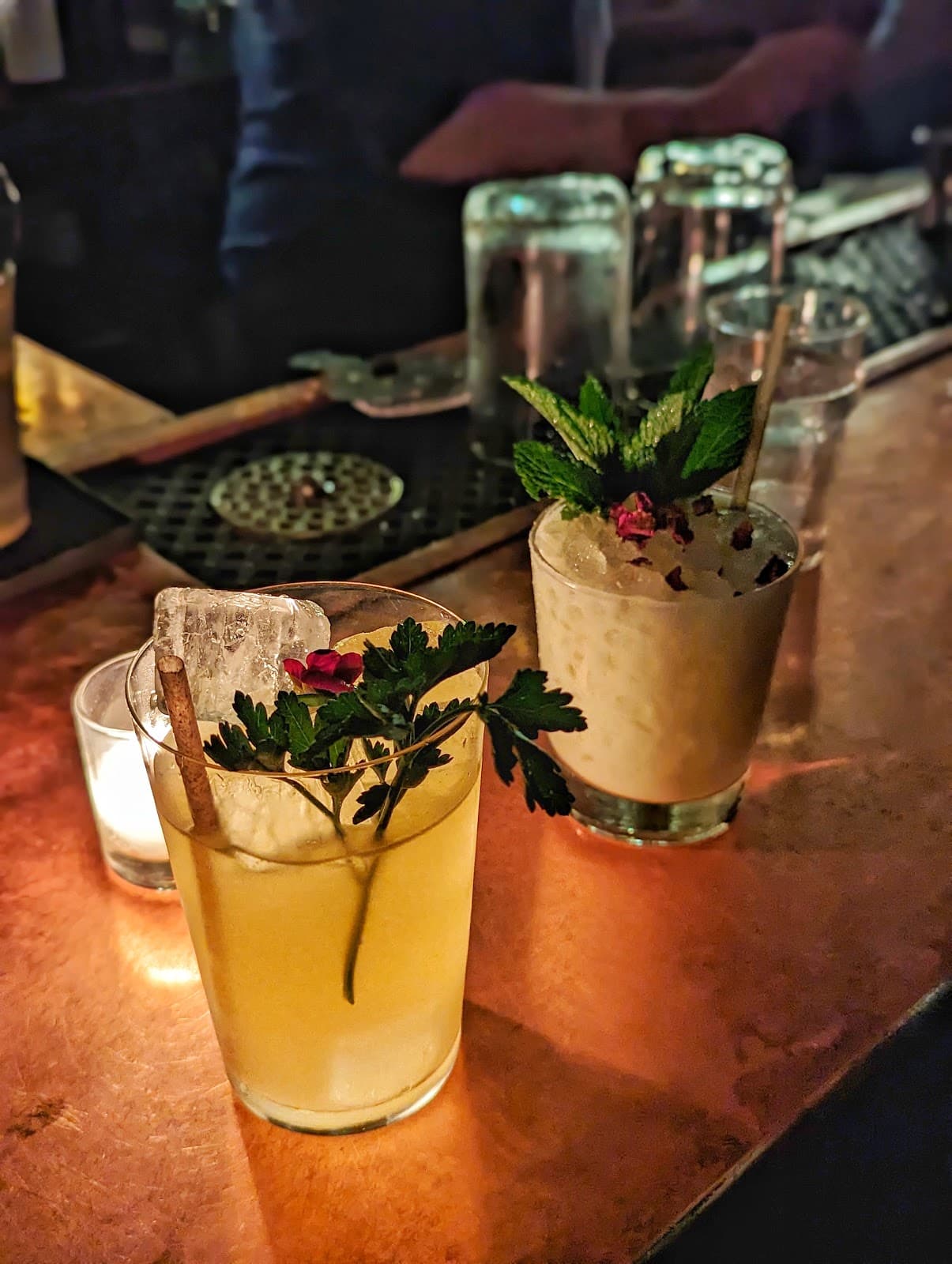 Close-up of craft cocktails on a dimly lit bar counter in New York