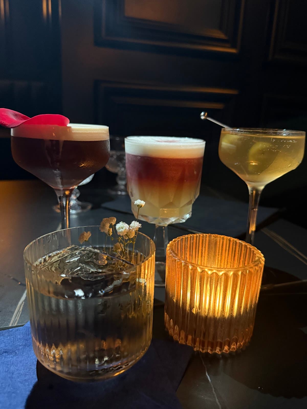 Elegant cocktails on a dimly lit table with a candle in Toronto