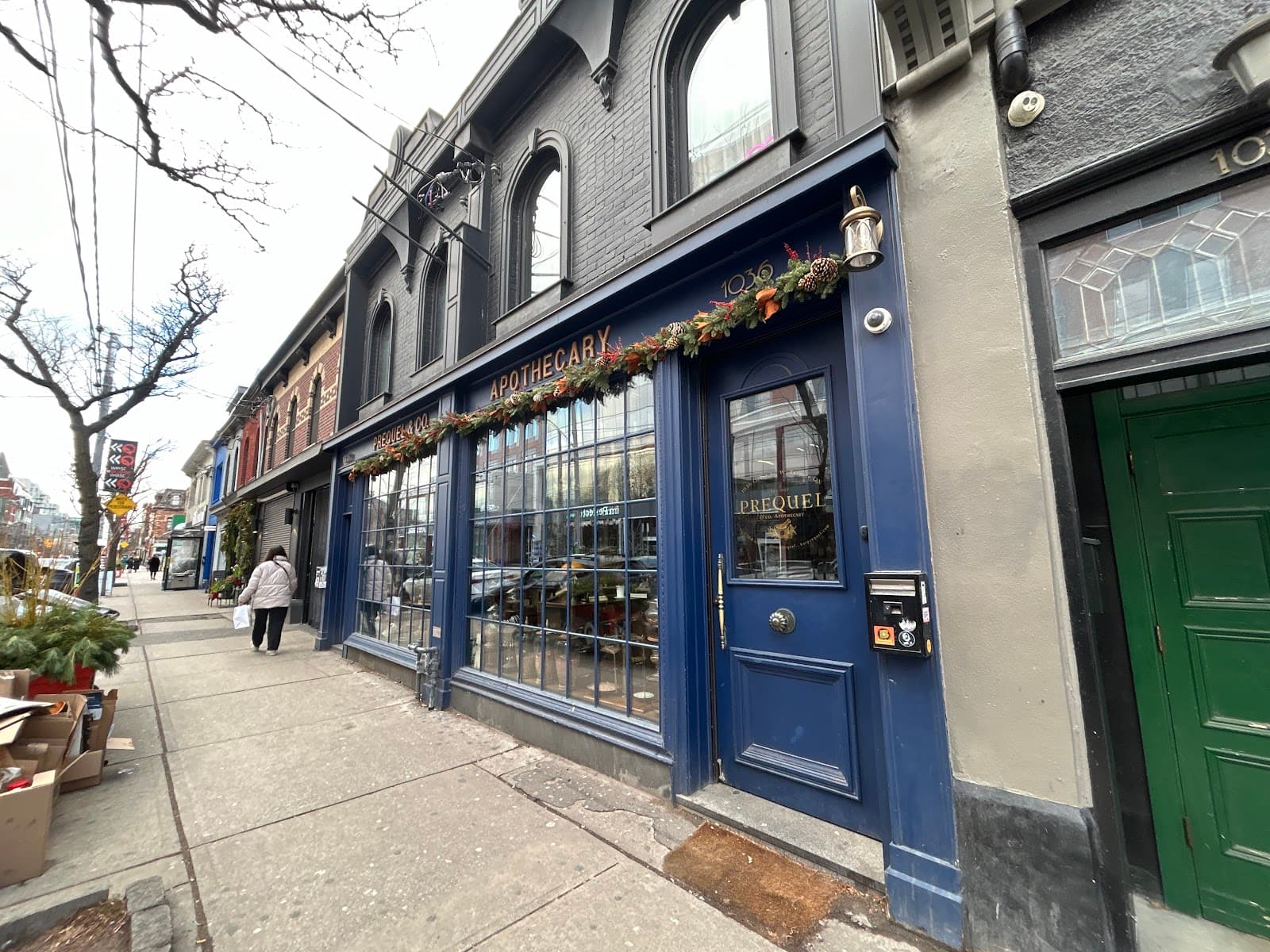 Blue exterior of Apothecary bar with festive decorations in Toronto